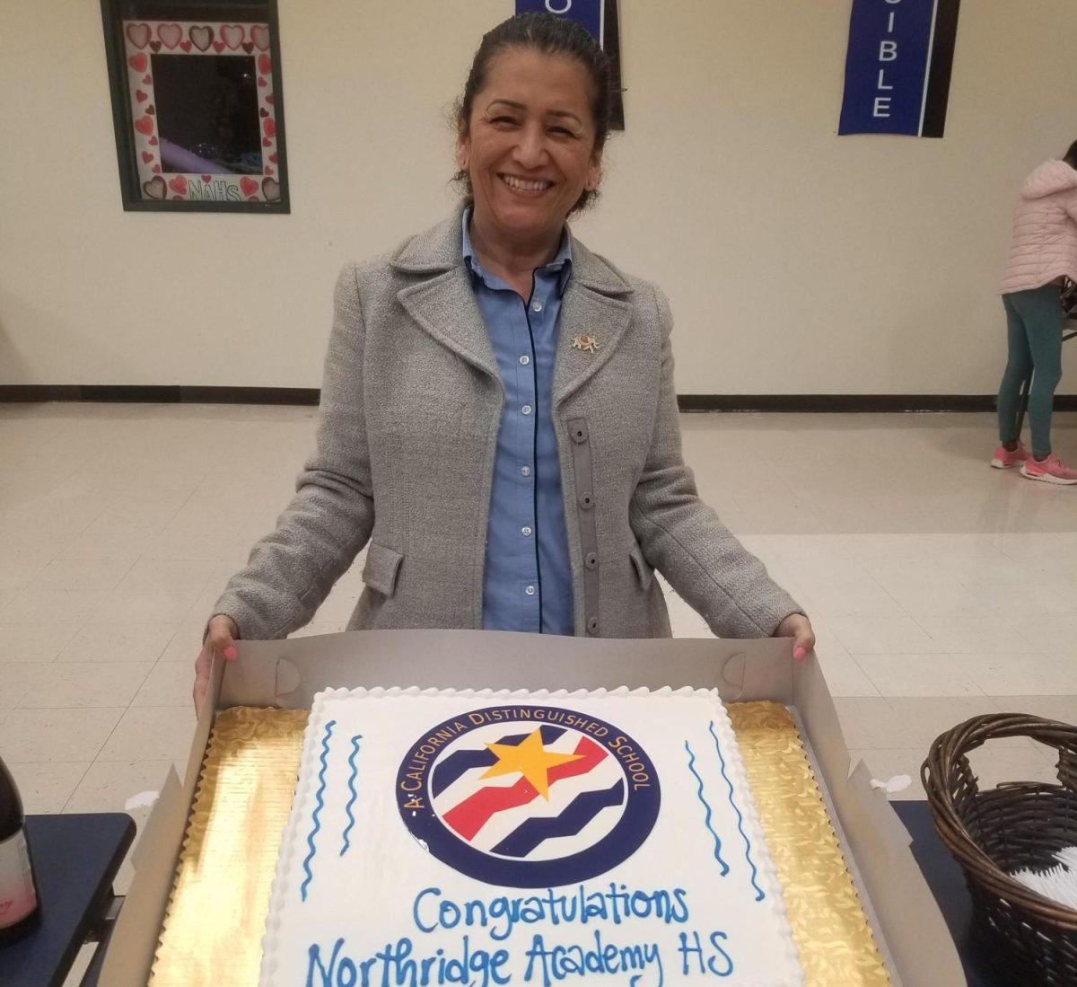 Proud Principal Castro presenting cake to the faculty, celebrating the honor.